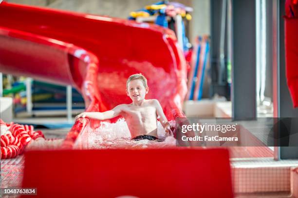 junge auf der wasserrutsche - hallenbad stock-fotos und bilder