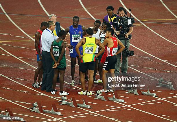 Starter Alan Bell talks to athletes during Mens' 100m first round at the Jawaharlal Nehru Stadium during day three of the Delhi 2010 Commonwealth...