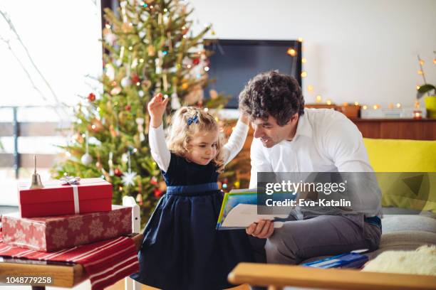 father is reading a christmas fairy tale - 2 year old book stock pictures, royalty-free photos & images