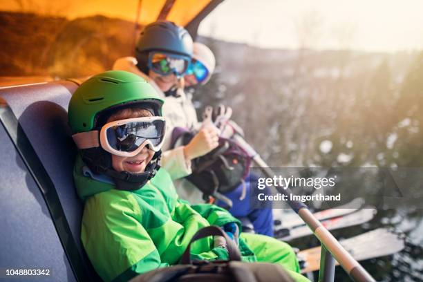 mother with kids sitting on a ski lift - kid skiing stock pictures, royalty-free photos & images