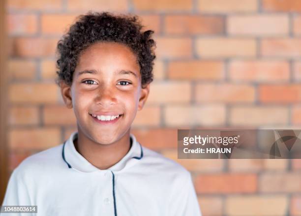 portrait of student standing against brick wall - junior high student stock pictures, royalty-free photos & images