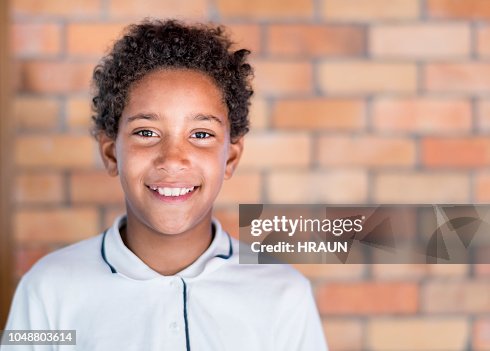 Retrato do aluno em pé contra a parede de tijolos Retrato do aluno em pé contra a parede de tijolos