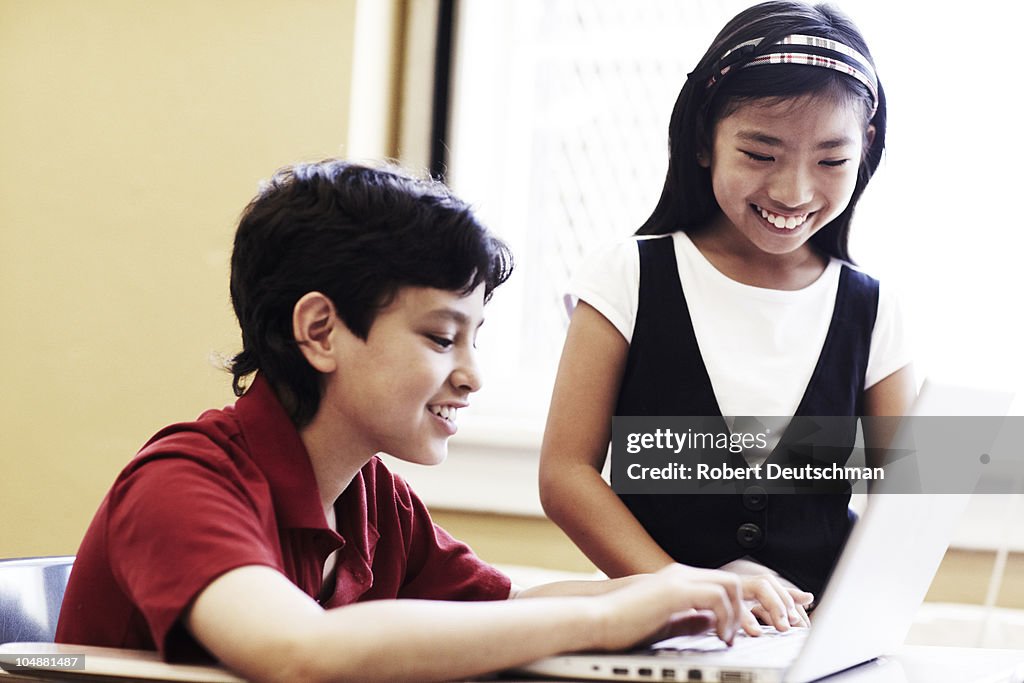 Kids with laptop computer at school