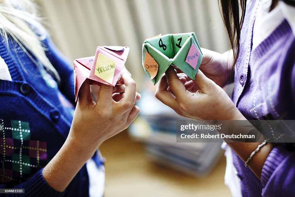 Two girls playing origami fortune game