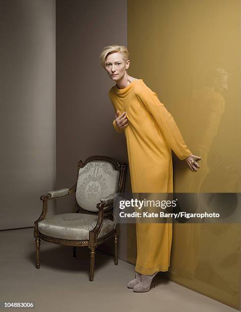 Actress Tilda Swinton poses at a portrait session for Madame Figaro Magazine in 2010. Silk dress by Adeline Andre, ring by Pomellato, shoes by...