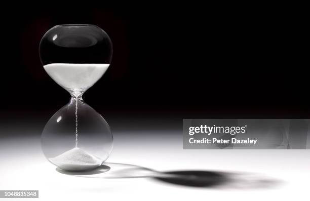 hourglass time with sand running through - sablier photos et images de collection