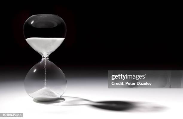 hourglass time with sand running through - tijdslimiet stockfoto's en -beelden