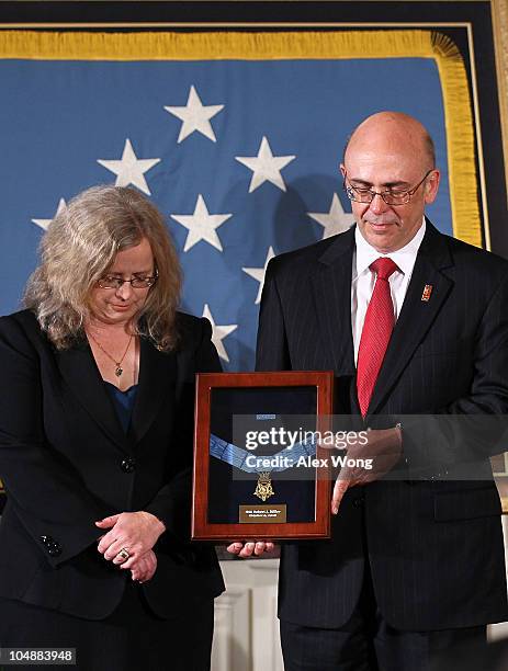 Phil Miller and Maureen Miller pray as they receive a Medal of Honor on behalf of their late son, Army Staff Sergeant Robert J. Miller, during an...