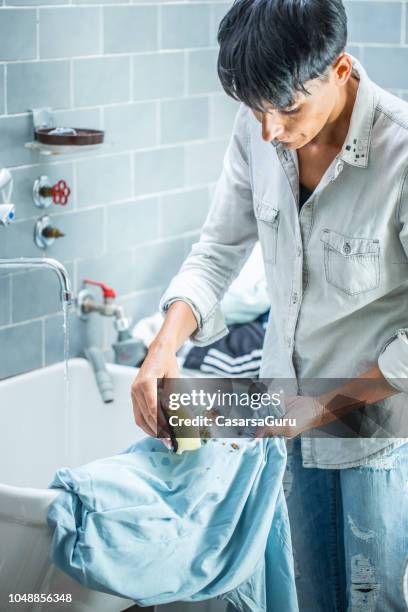 adult woman cleaning stained clothing - stained laundry stock pictures, royalty-free photos & images
