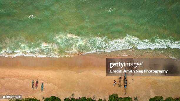 aerial view of a sandy beach with fisherman, their boats and beautiful clear sea water - mangalore fotografías e imágenes de stock