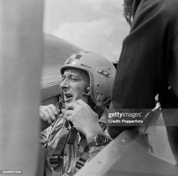 British engineer and speed record breaker Donald Campbell pictured fastening his helmet in the cockpit of his Bluebird-Proteus CN7 gas turbine car...