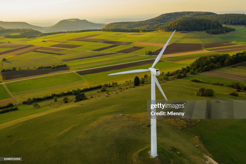 Alternative Energien Windkraftanlage in schönen grünen Landschaft bei Sonnenuntergang