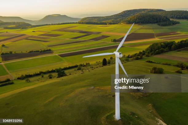 turbina de viento de energía alternativa en verde paisaje al atardecer - aerogenerador fotografías e imágenes de stock