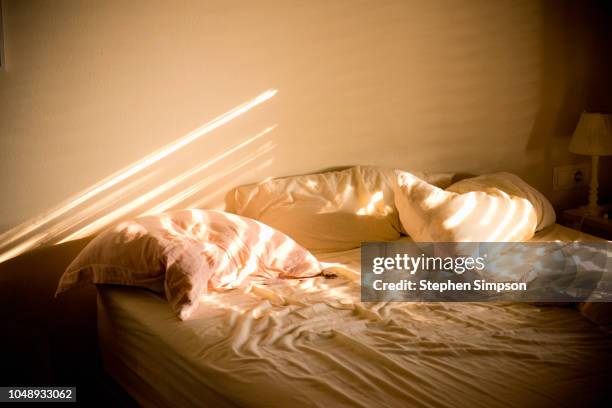 sunlight on messy bed in home - beds stock pictures, royalty-free photos & images