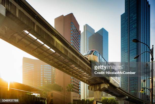kuala lumpur elevated monorail in chow kit back lit by sunrise - kuala lumpur stock pictures, royalty-free photos & images
