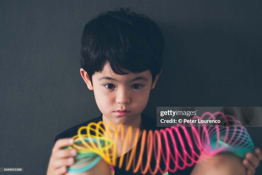 Boy holding a colourful slinky