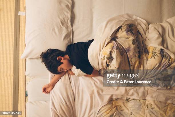 boy sleeping on futon - tatami matte stock-fotos und bilder