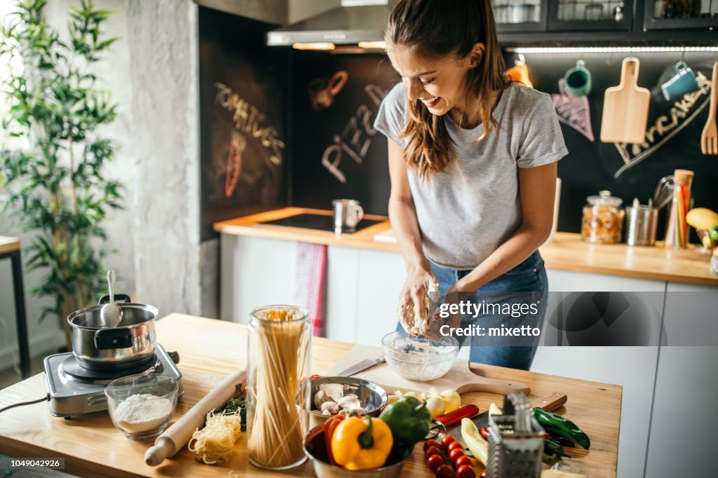 Young woman preparing pizza