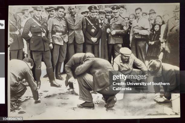 Photograph of a group of Jews scrubbing streets of Vienna, Austria. 'Indignities like this have aroused worldwide protests against the Hitler regime...