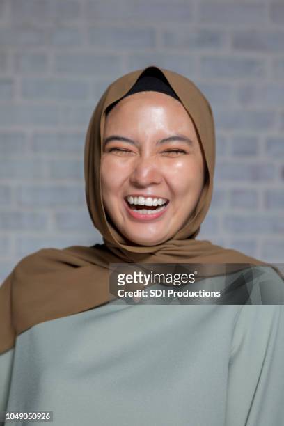 portrait of laughing malaysian woman with eyes closed - funny muslim stock pictures, royalty-free photos & images