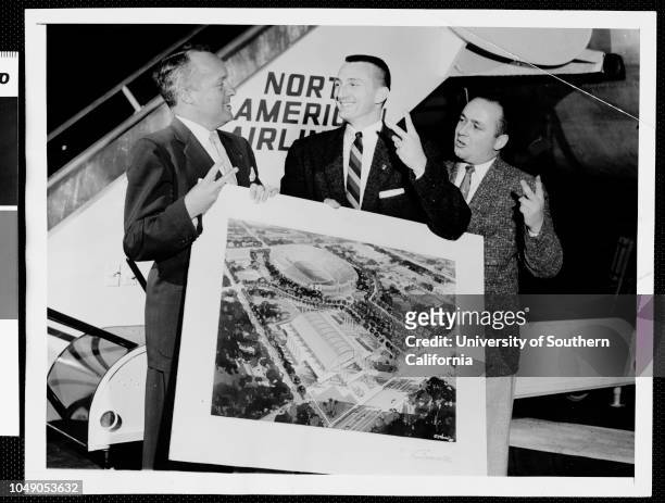 Photograph of Harold Voegelin, David Holt and Dick Fitzgerald holding architects drawing for the planned new Sports Arena, 1956. 'The golden stare in...