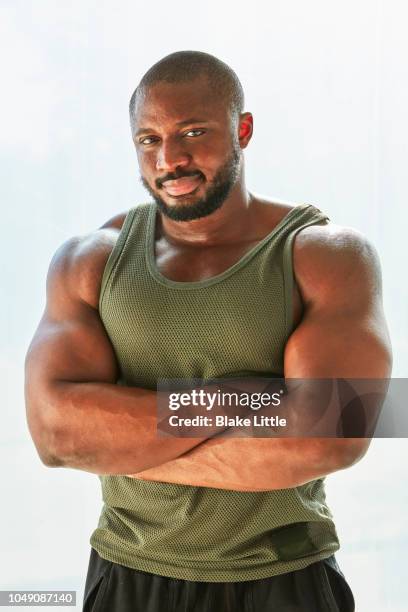 muscular african american man wearing olive tank top - bodybuilder posing stock pictures, royalty-free photos & images
