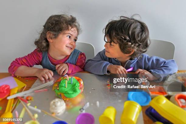 two children boy and a girl playing together at home - play date ストックフォトと画像