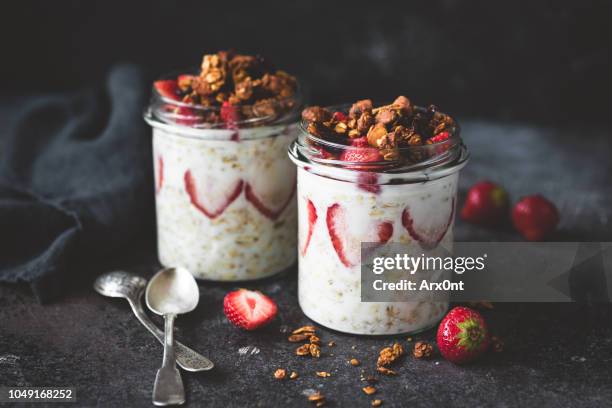 overnight oats with strawberries and granola in jar - oats food fotografías e imágenes de stock