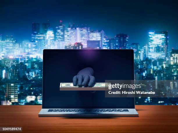 hacker's hand stealing money from laptop computer monitor - stealing idea stock pictures, royalty-free photos & images