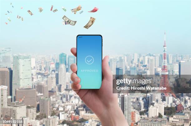 mobile payment. woman's hand has smartphone with banknote in the sky. - mobile money stock-fotos und bilder