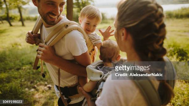 family of adventurers - baby carrier stock pictures, royalty-free photos & images