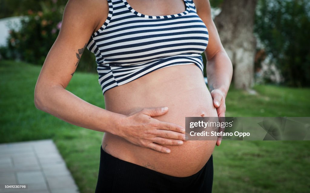 Pregnant woman gently rub her belly
