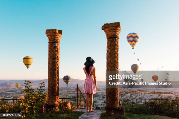 pretty asian girl watching colorful hot air balloons flying over the valley at cappadocia, turkey - hot middle eastern women stock pictures, royalty-free photos & images