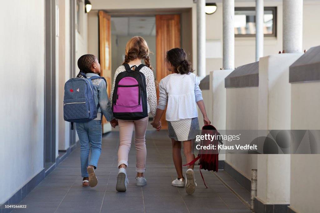 Girlfriends walking hand in hand on school isle