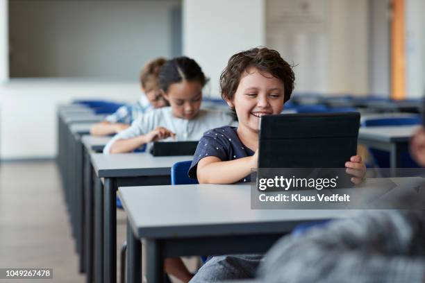 children working on tablet in classroom - kids modern school life stock-fotos und bilder