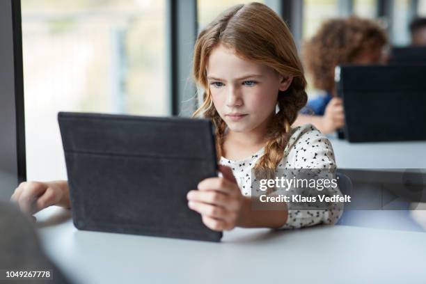 girl reading on tablet at school - elementary age girls stock pictures, royalty-free photos & images
