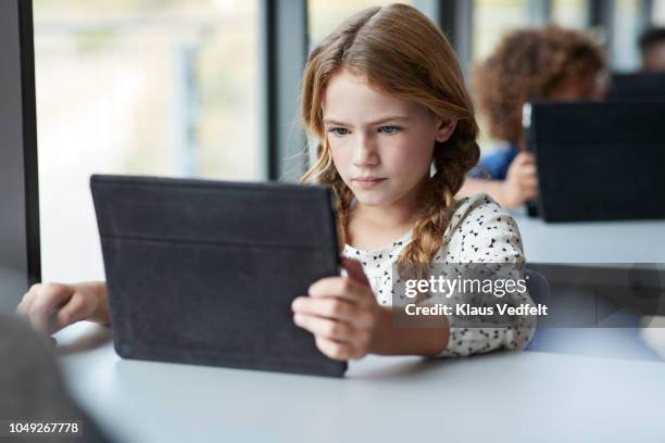 girl reading on tablet at school - reading digital tablet stock pictures, royalty-free photos & images