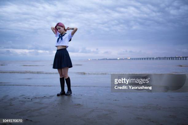 portrait of asian japanese school girl costume looking at beach in twilight - ragazza scuola foto e immagini stock