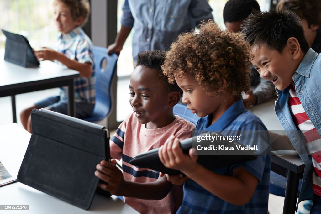 Children looking at tablet together in classroom
