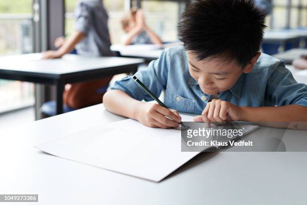 boy drawing in book in classroom - japanese elementary school bildbanksfoton och bilder