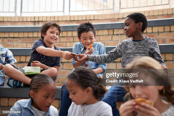 school children having lunch together outside the building - 8歳から9歳 ストックフォトと画像