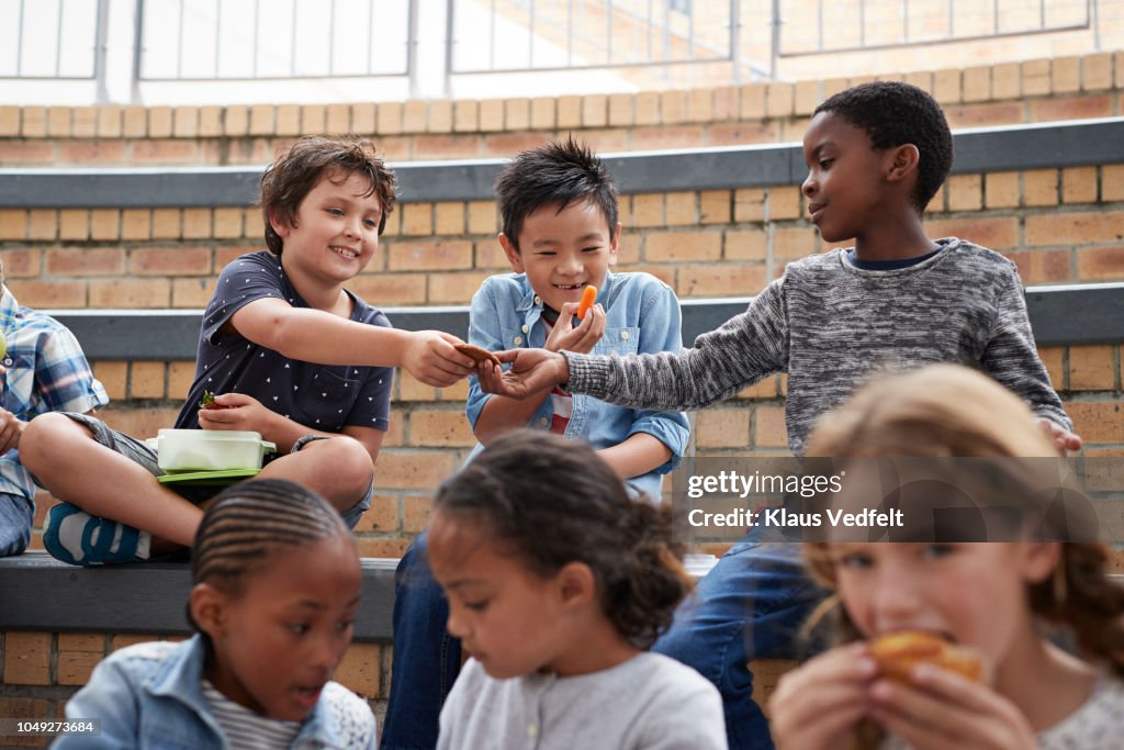 School children having lunch together outside the building