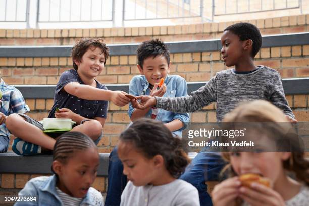 school children having lunch together outside the building - sharing stock pictures, royalty-free photos & images