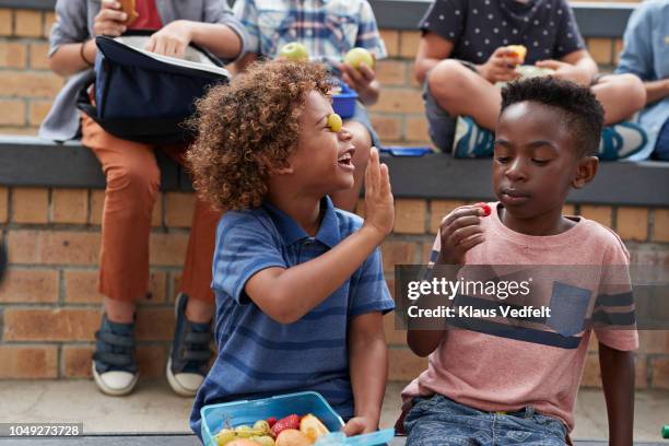 school children having lunch together outside the building - parte inferior fotografías e imágenes de stock