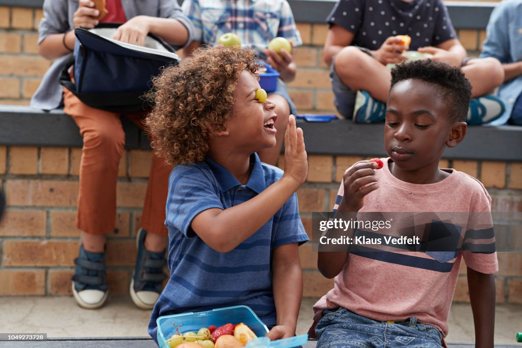 School children having lunch together outside the building