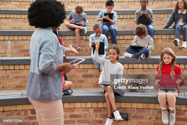 school children & teacher having class outside with digital tablets - digital techniques ストックフォトと画像