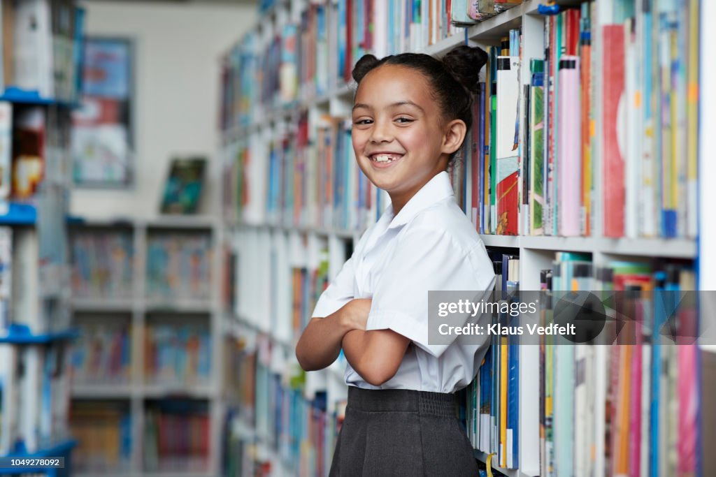 Portrait of cute schoolgirl at the library