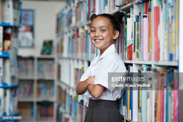 Portrait of cute schoolgirl at the library