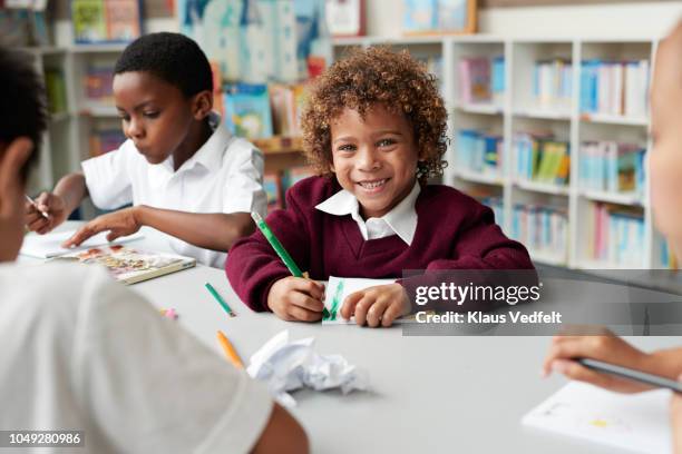 school children drawing at the library - child at school photos et images de collection