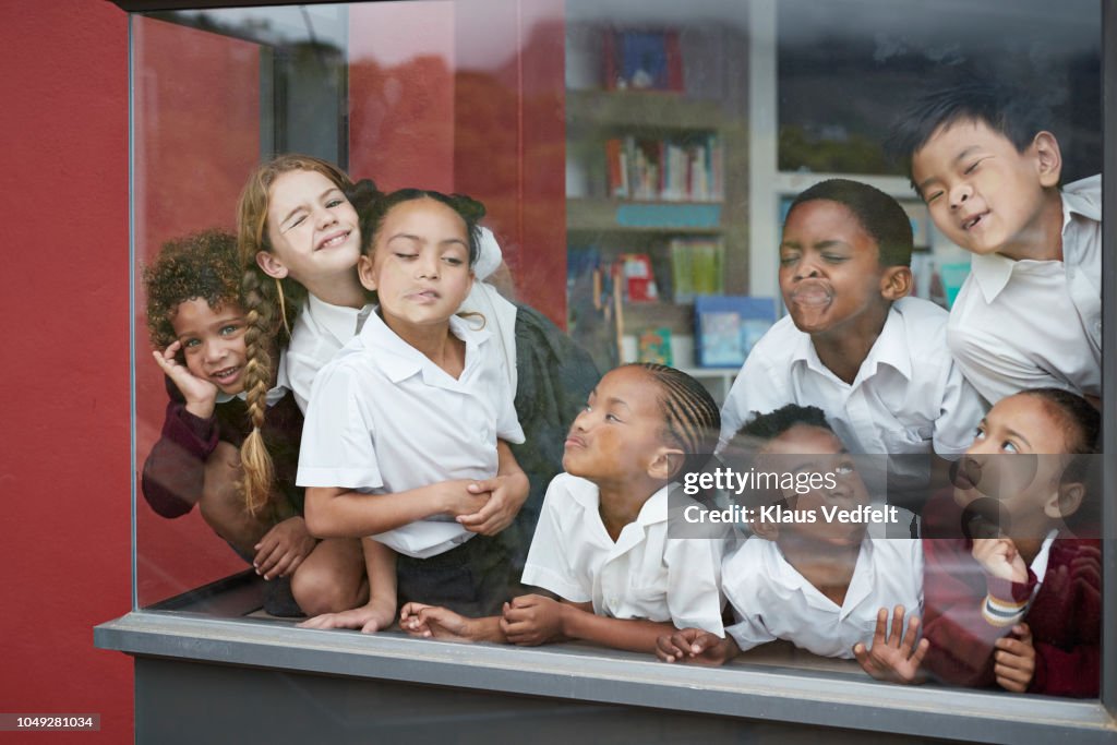 School children pressing their faces against the window in the library
